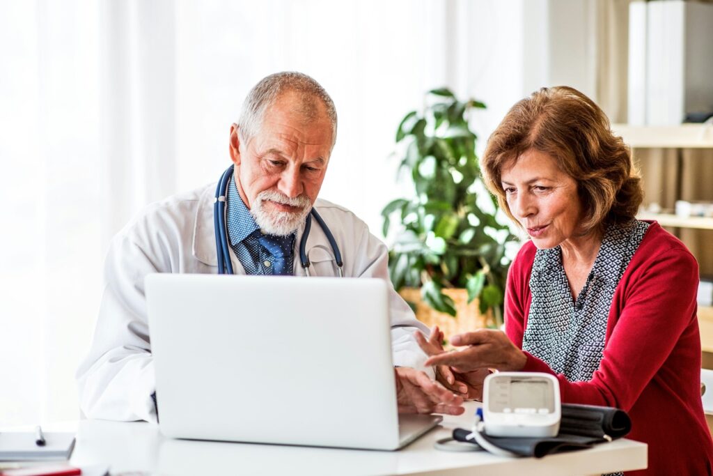 A woman and doctor looking at a laptop